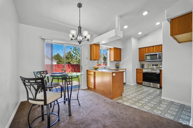 7842 Arlington Dr, Nampa, ID 83687 - kitchen with stainless steel appliances, a peninsula, a chandelier, baseboards, and vaulted ceiling