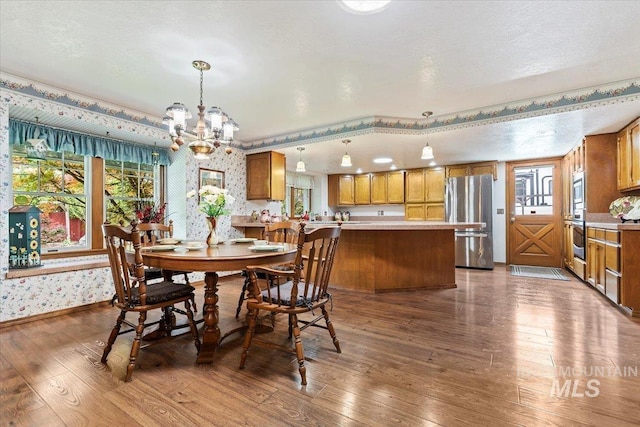 3428 N Columbine Ave, Boise, ID 83713 - dining room with a chandelier, wallpapered walls, and dark wood-style floors