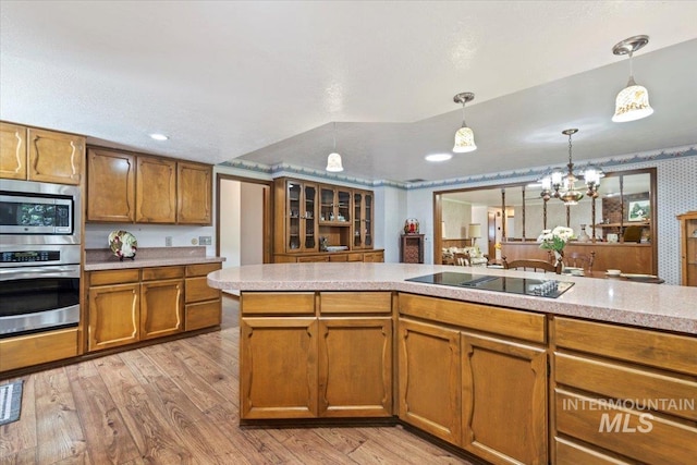 3428 N Columbine Ave, Boise, ID 83713 - kitchen with stainless steel appliances, brown cabinetry, light wood-style flooring, light countertops, and pendant lighting