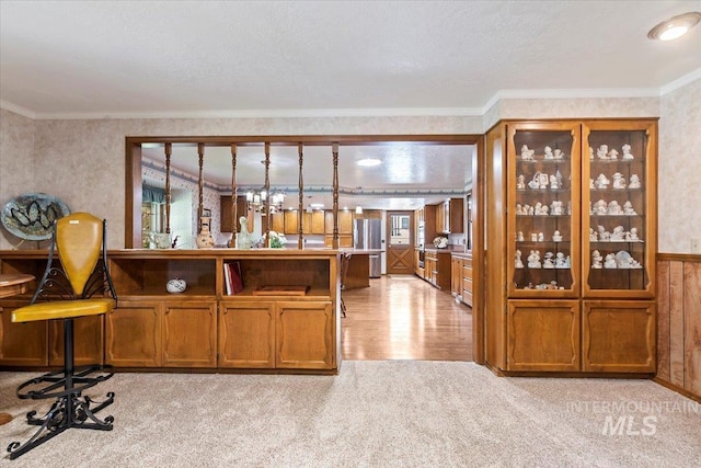 3428 N Columbine Ave, Boise, ID 83713 - bar area featuring light colored carpet, crown molding, freestanding refrigerator, light wood-style floors, and a wainscoted wall