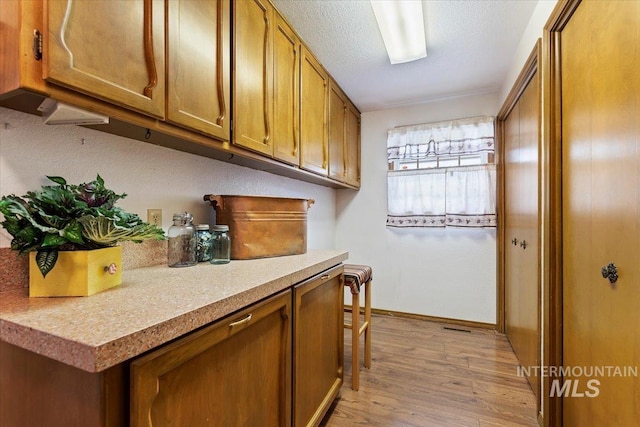 3428 N Columbine Ave, Boise, ID 83713 - kitchen featuring brown cabinets, light wood-style floors, light countertops, and baseboards