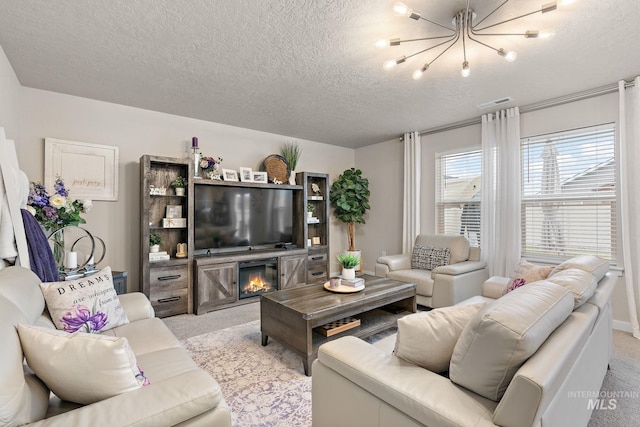 living room featuring a fireplace, light colored carpet, a textured ceiling, and an inviting chandelier