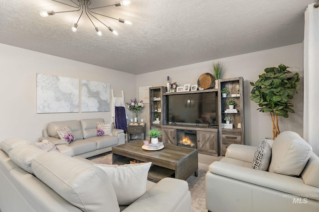 living room with a fireplace, a textured ceiling, carpet floors, and a notable chandelier