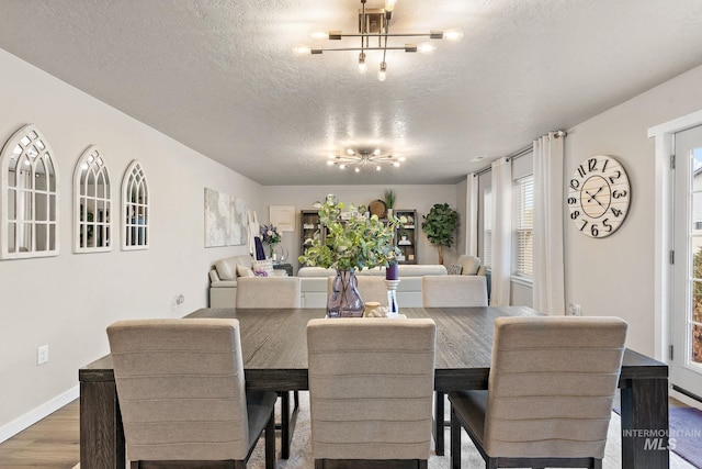 dining room featuring dark hardwood / wood-style flooring, a textured ceiling, and a chandelier