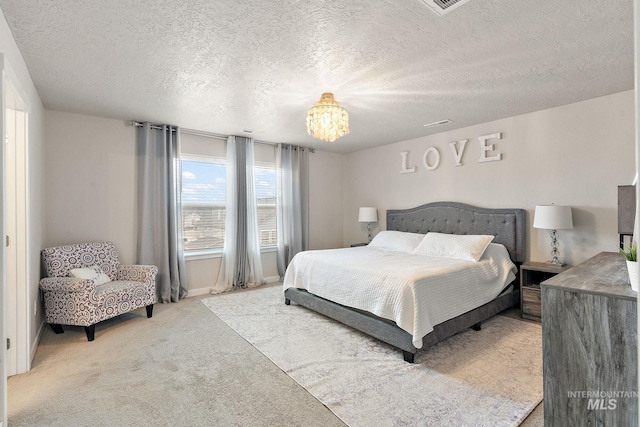 carpeted bedroom featuring a notable chandelier and a textured ceiling