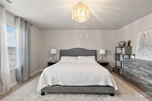 carpeted bedroom with a chandelier and a textured ceiling