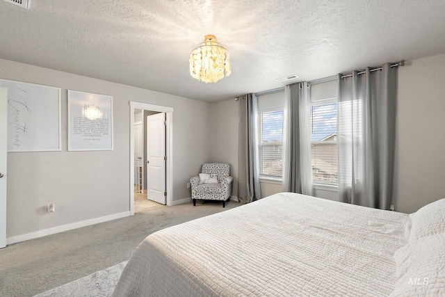 carpeted bedroom featuring a textured ceiling and a notable chandelier