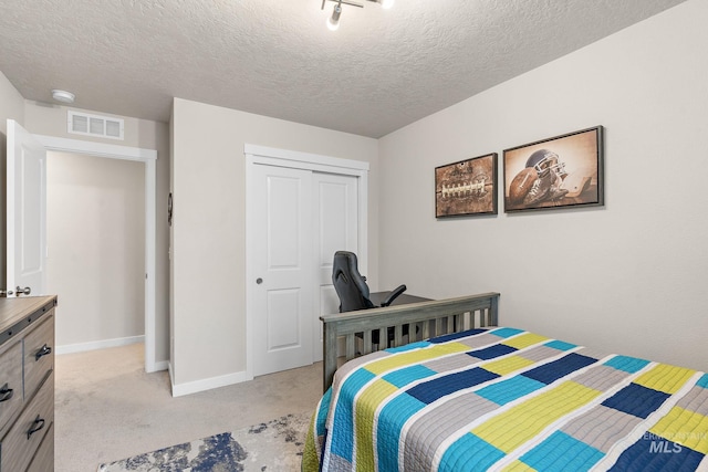 carpeted bedroom featuring a closet and a textured ceiling