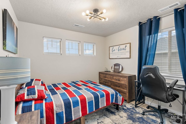 bedroom with an inviting chandelier, carpet floors, a textured ceiling, and multiple windows