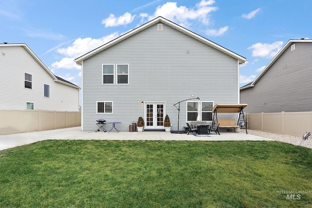 back of house featuring a lawn, a patio area, and french doors