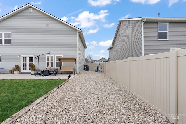 back of property with french doors, a yard, and a patio area