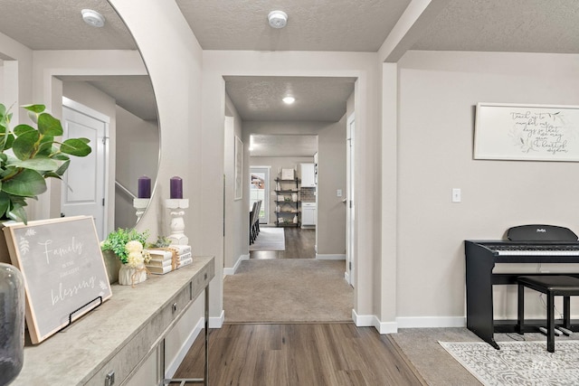 hallway featuring wood-type flooring and a textured ceiling