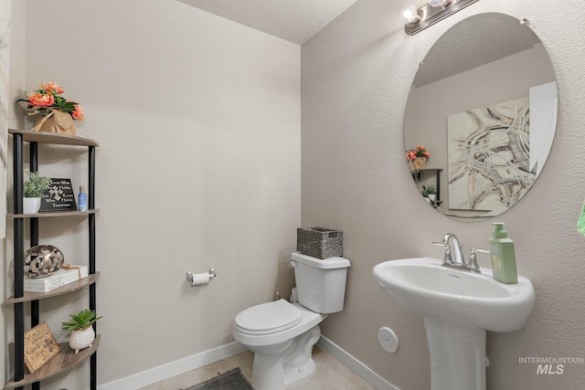 bathroom featuring tile patterned flooring, a textured ceiling, and toilet