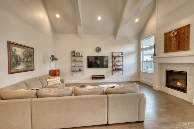 living room with vaulted ceiling with beams, wood-type flooring, and a tiled fireplace