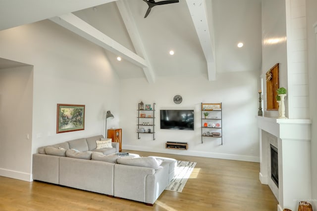 living room with beamed ceiling, high vaulted ceiling, and light hardwood / wood-style flooring