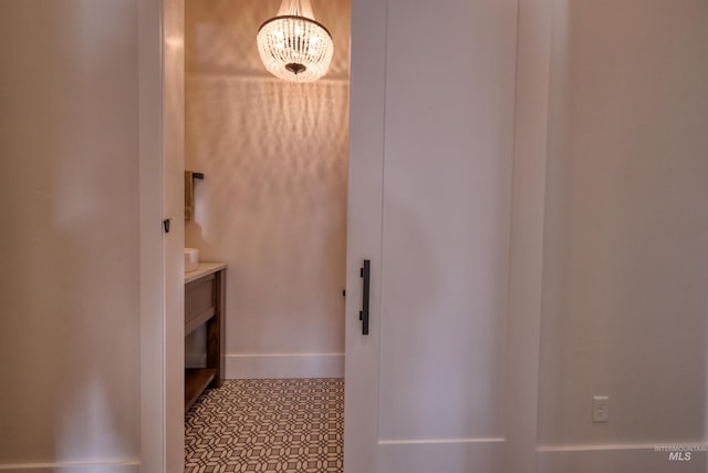 bathroom featuring tile patterned flooring and an inviting chandelier