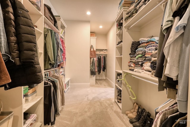 walk in closet featuring light colored carpet