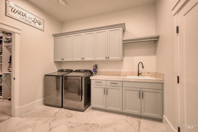 clothes washing area featuring sink, cabinets, and independent washer and dryer