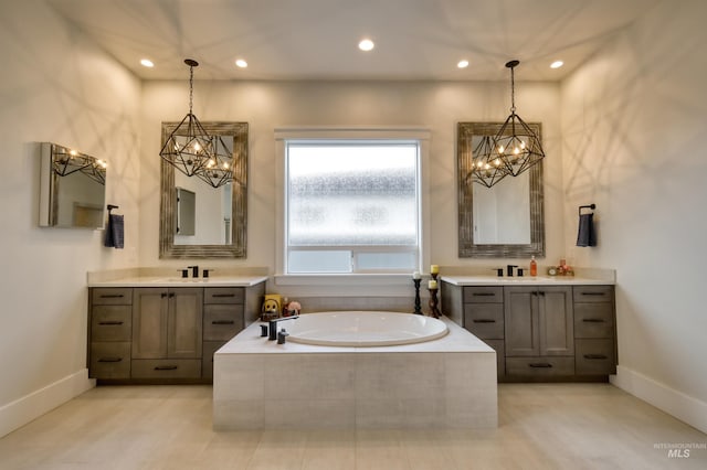 bathroom featuring tile patterned floors, vanity, and tiled tub