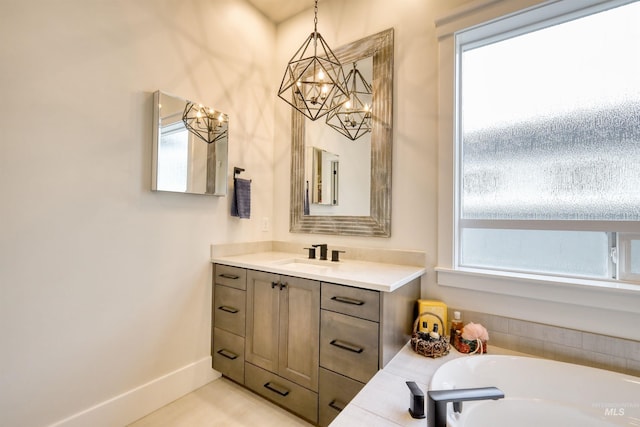 bathroom featuring vanity, a tub to relax in, and an inviting chandelier