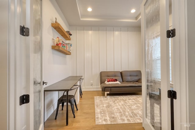 mudroom featuring a tray ceiling and light hardwood / wood-style flooring