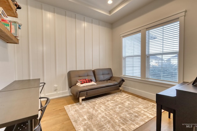 living area with hardwood / wood-style flooring and a raised ceiling