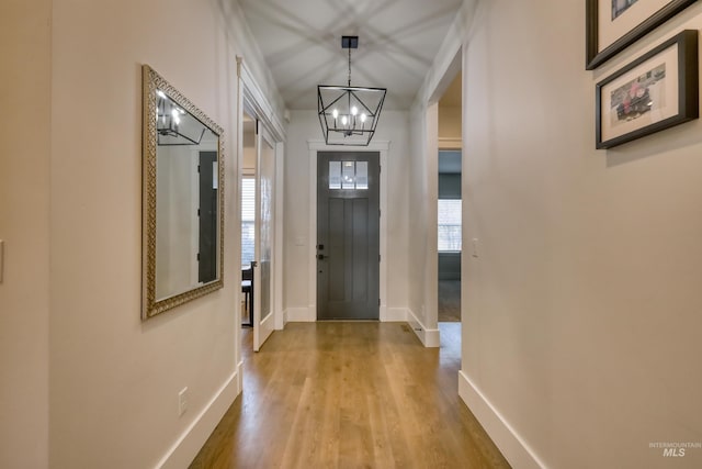 entryway with light hardwood / wood-style floors, a healthy amount of sunlight, and a chandelier