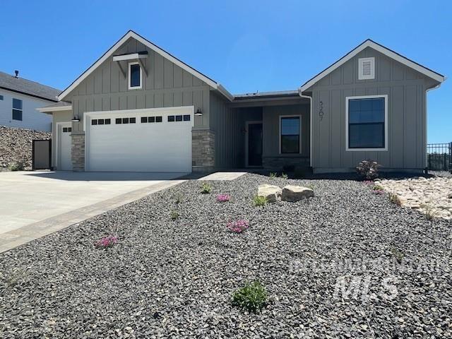 5207 W Kloe Ct Unit 808, Boise, ID 83714 - view of front of house with board and batten siding, an attached garage, driveway, and stone siding