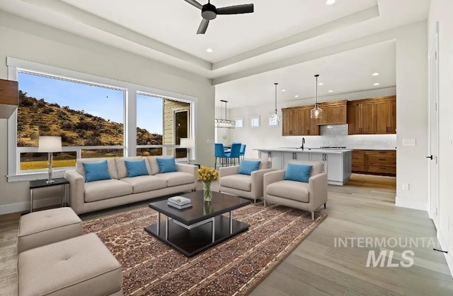 5207 W Kloe Ct Unit 808, Boise, ID 83714 - living area featuring a ceiling fan, light wood-type flooring, recessed lighting, baseboards, and a tray ceiling