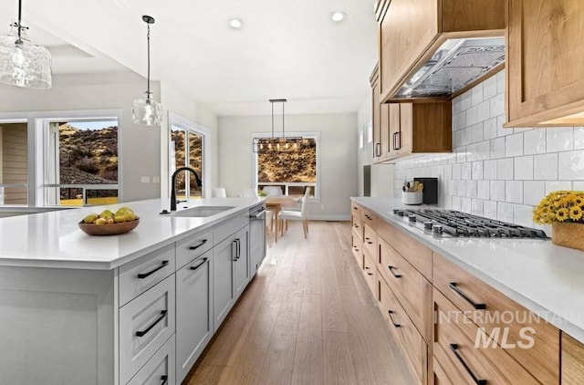 5207 W Kloe Ct Unit 808, Boise, ID 83714 - kitchen with a sink, light countertops, stainless steel appliances, decorative backsplash, and light wood-style flooring
