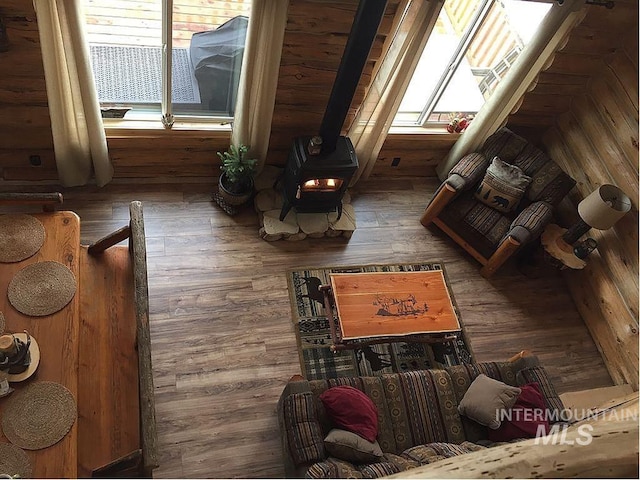 living area with wood-type flooring and a wood stove