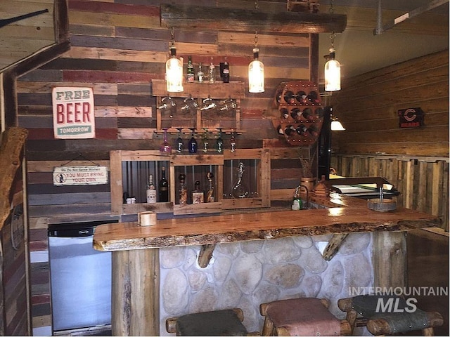 bar featuring pendant lighting and wooden walls