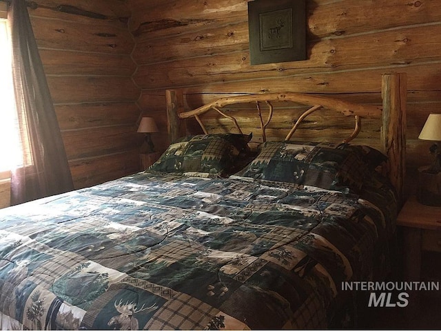 bedroom featuring log walls