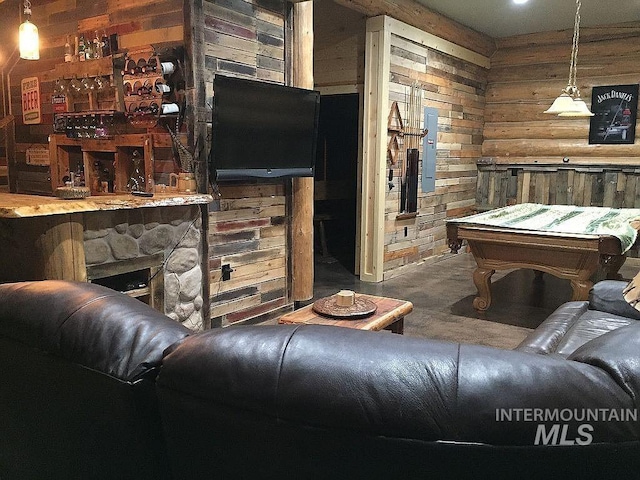 interior space with wooden walls, a fireplace, and rustic walls