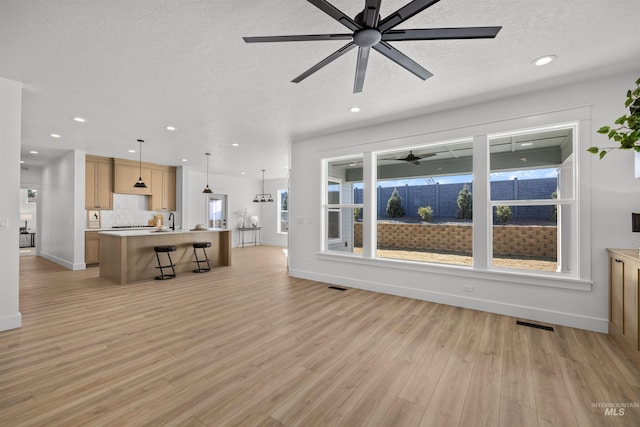 5687 S Snowden Ave, Meridian, ID 83642 - unfurnished living room featuring recessed lighting, a textured ceiling, and light wood-type flooring