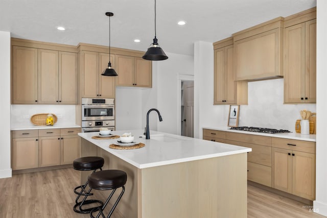 5687 S Snowden Ave, Meridian, ID 83642 - kitchen featuring light brown cabinetry, a sink, stainless steel appliances, light wood-style floors, and light countertops