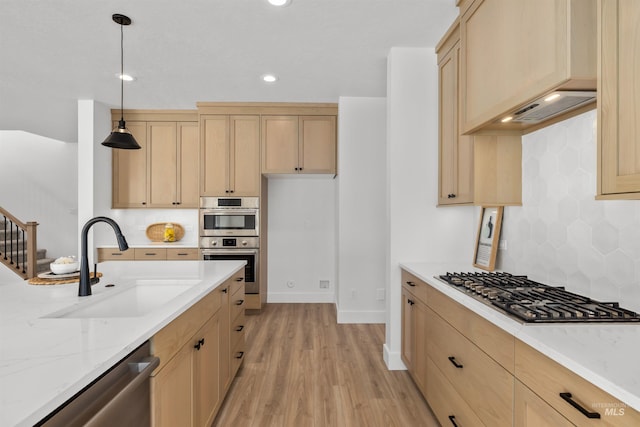 5687 S Snowden Ave, Meridian, ID 83642 - kitchen featuring light stone counters, light brown cabinetry, a sink, light wood-style floors, and appliances with stainless steel finishes