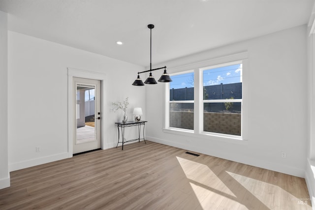 5687 S Snowden Ave, Meridian, ID 83642 - unfurnished dining area with a wealth of natural light, visible vents, baseboards, and wood finished floors