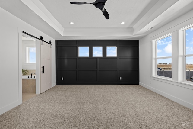5687 S Snowden Ave, Meridian, ID 83642 - unfurnished bedroom featuring a raised ceiling, a barn door, and carpet floors