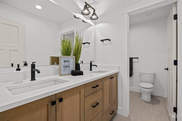 5687 S Snowden Ave, Meridian, ID 83642 - bathroom with double vanity, toilet, visible vents, and a sink