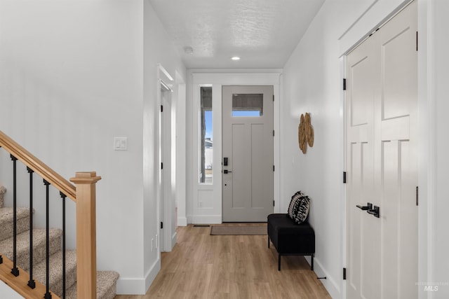 5687 S Snowden Ave, Meridian, ID 83642 - foyer with baseboards, stairs, recessed lighting, light wood-style floors, and a textured ceiling
