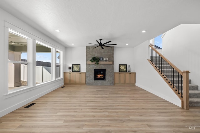 5687 S Snowden Ave, Meridian, ID 83642 - unfurnished living room featuring baseboards, stairway, light wood-type flooring, recessed lighting, and a fireplace