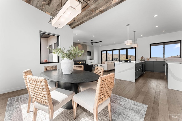 4135 N Hawkeye Pl, Boise, ID 83703 - dining area featuring wood-type flooring, recessed lighting, a large fireplace, beam ceiling, and baseboards