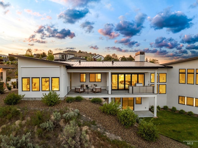 4135 N Hawkeye Pl, Boise, ID 83703 - back of property at dusk with a standing seam roof, stucco siding, and metal roof