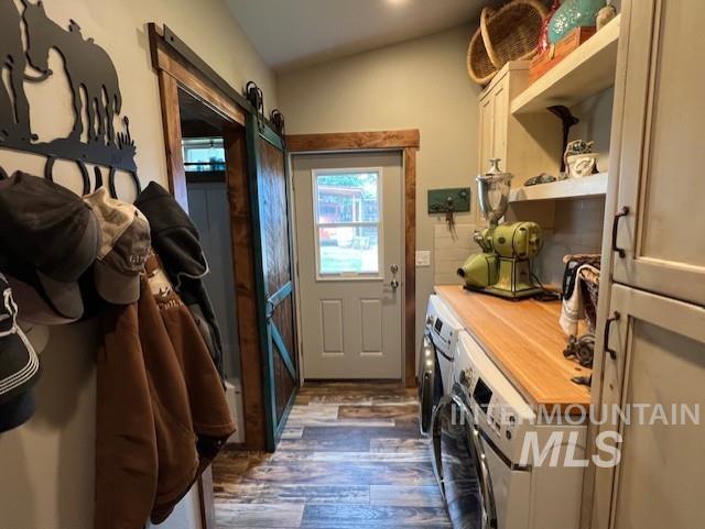 mudroom with dark hardwood / wood-style floors, vaulted ceiling, and washer and clothes dryer