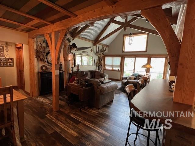 living room with ceiling fan, dark hardwood / wood-style floors, and lofted ceiling with beams