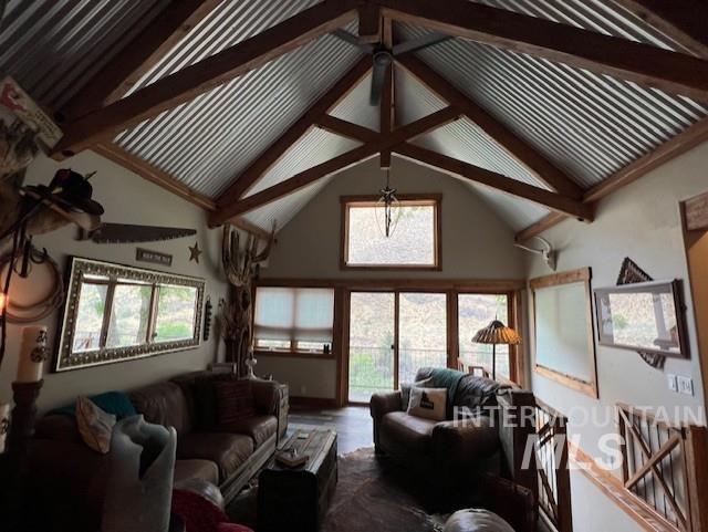 living room featuring high vaulted ceiling, a healthy amount of sunlight, beamed ceiling, and wood-type flooring