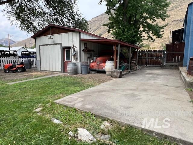 view of outdoor structure with a carport and a yard