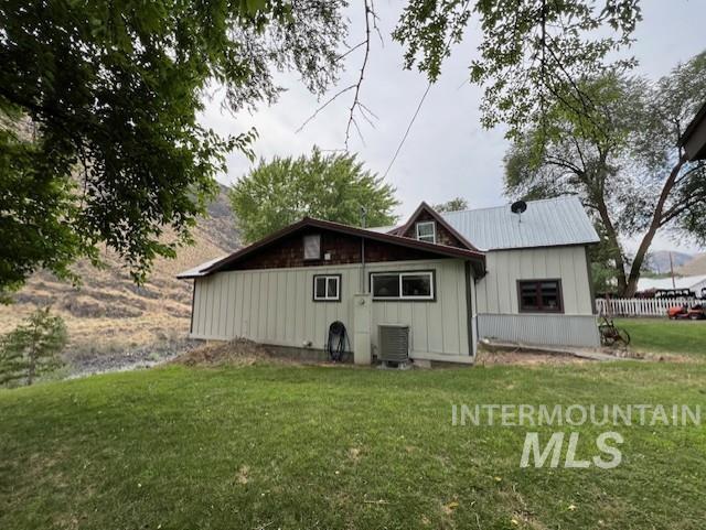 rear view of house with a yard and central AC