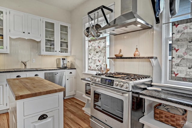1707 W Resseguie St, Boise, ID 83702 - kitchen featuring wall chimney range hood, appliances with stainless steel finishes, butcher block counters, and healthy amount of natural light